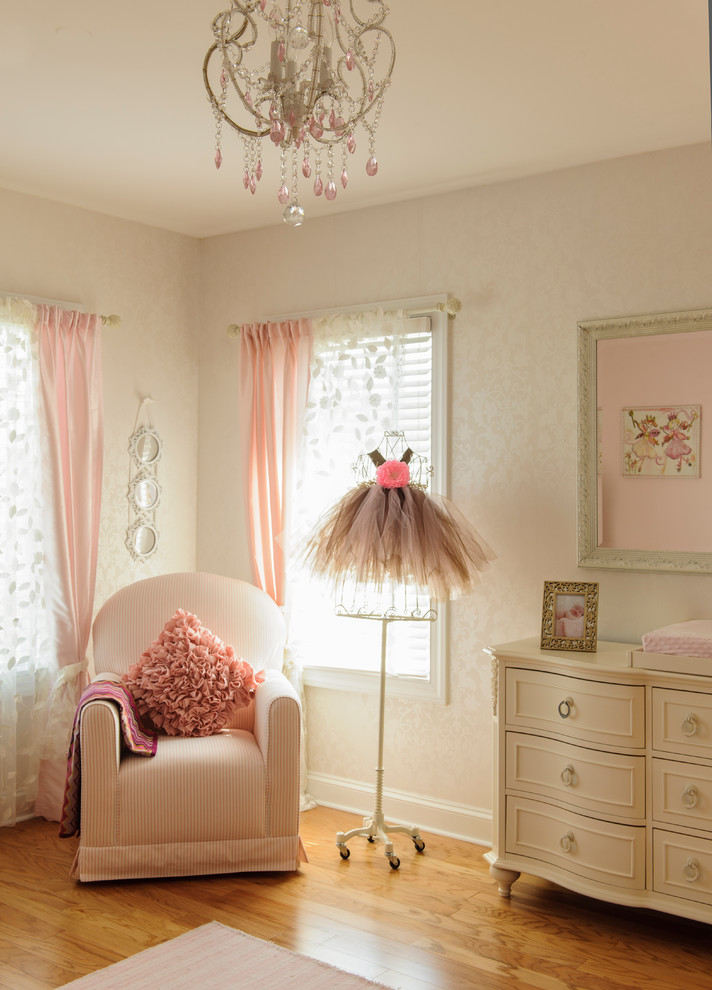 This is an example of a medium sized traditional nursery for girls in New York with beige walls, medium hardwood flooring and orange floors.