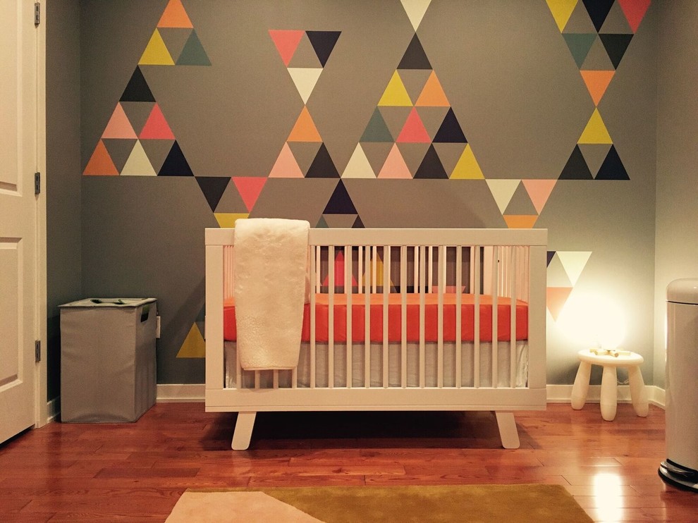 Design ideas for a medium sized modern nursery for boys in Philadelphia with grey walls, medium hardwood flooring and brown floors.