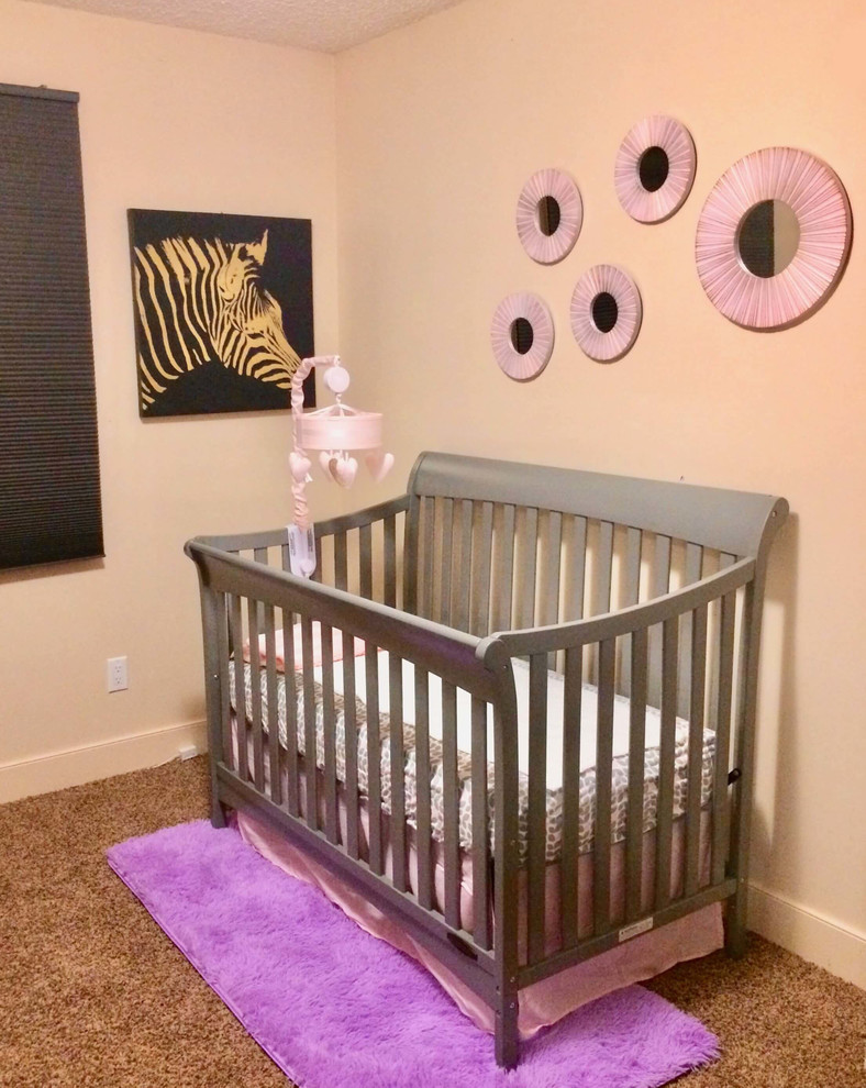 Cette photo montre une petite chambre de bébé fille tendance avec un mur beige, moquette et un sol beige.