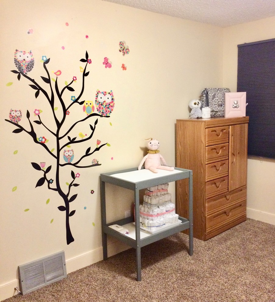 Imagen de habitación de bebé niña actual pequeña con paredes beige, moqueta y suelo beige