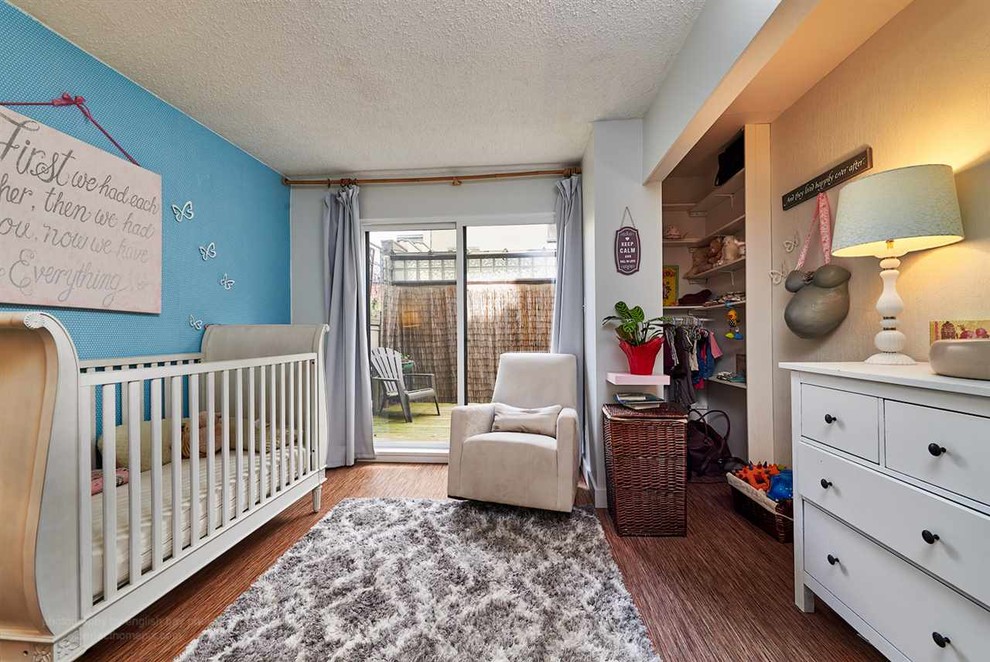 Cette photo montre une chambre de bébé neutre chic de taille moyenne avec un mur bleu, parquet en bambou et un sol marron.