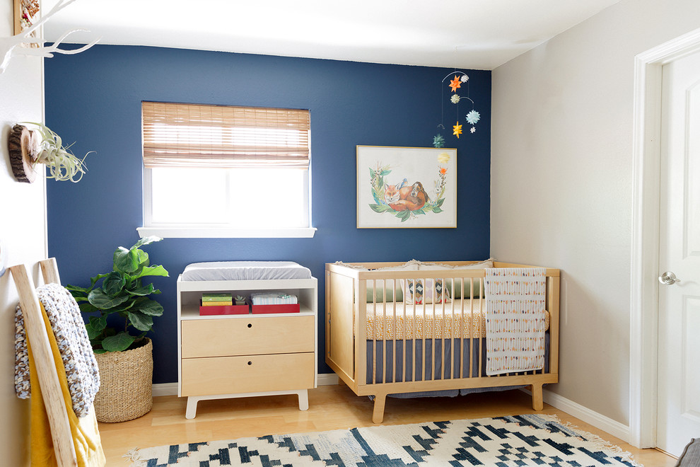 Пример оригинального дизайна: нейтральная комната для малыша в скандинавском стиле с синими стенами, светлым паркетным полом и бежевым полом