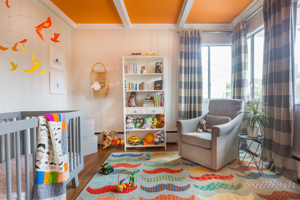 Foto de habitación de bebé neutra retro de tamaño medio con suelo de madera en tonos medios, paredes blancas y suelo marrón