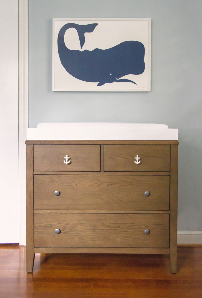 Réalisation d'une petite chambre de bébé neutre marine avec un mur bleu et un sol en bois brun.