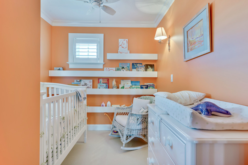 Diseño de habitación de bebé neutra costera de tamaño medio con parades naranjas, moqueta y suelo blanco