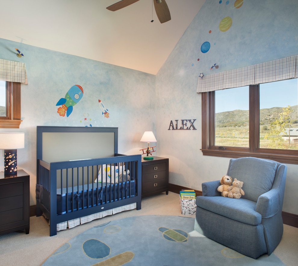 This is an example of a large traditional nursery for boys in Denver with blue walls and carpet.