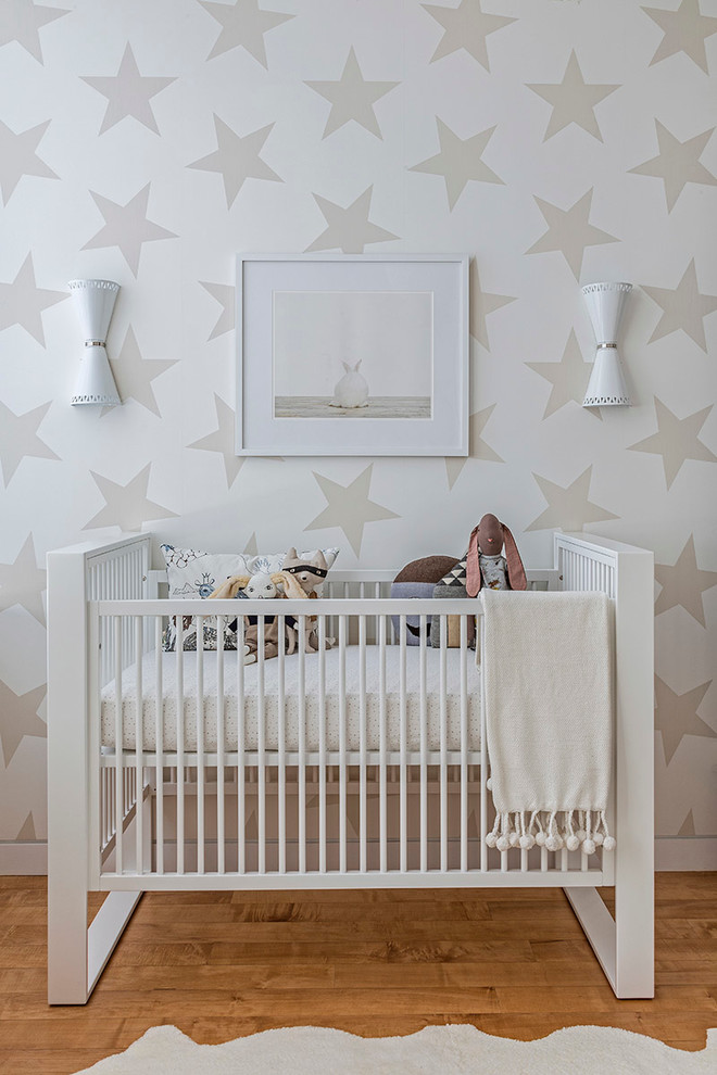 На фото: нейтральная комната для малыша в современном стиле с разноцветными стенами и светлым паркетным полом с