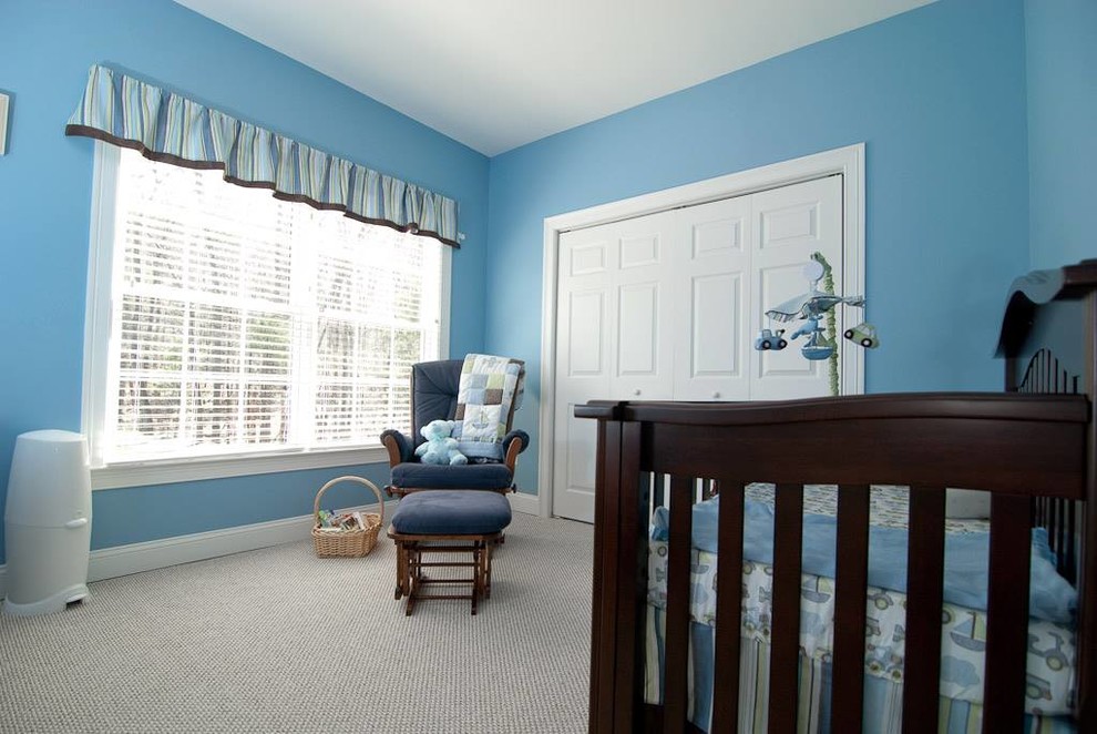 Cette image montre une chambre de bébé garçon traditionnelle de taille moyenne avec un mur bleu et moquette.