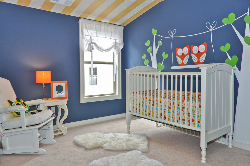 Cette image montre une petite chambre de bébé neutre bohème avec un mur bleu et moquette.