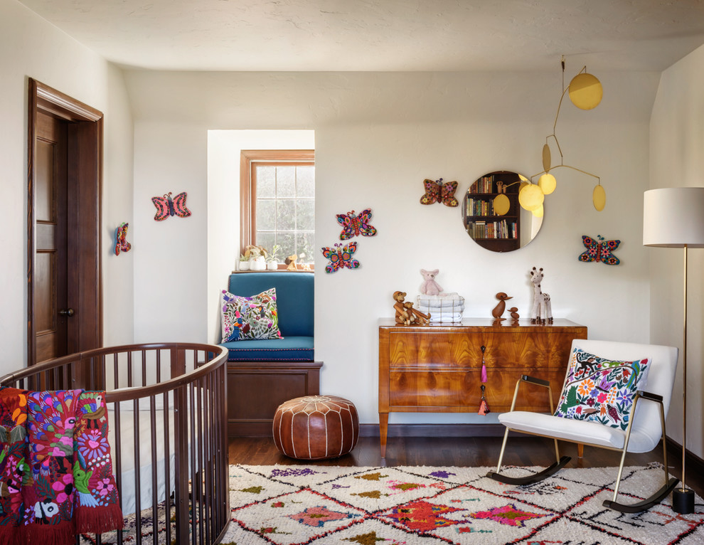 Idée de décoration pour une chambre de bébé tradition avec un mur blanc, parquet foncé et un sol marron.