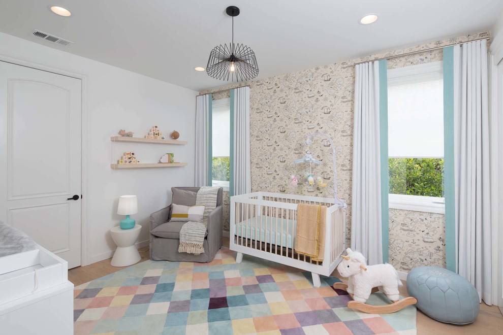 Cette photo montre une chambre de bébé tendance avec un mur blanc, un sol en bois brun et un sol marron.