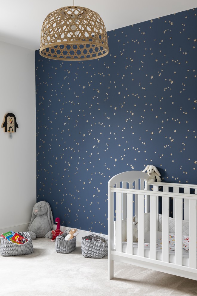 Large contemporary nursery for girls in London with blue walls, carpet and grey floors.