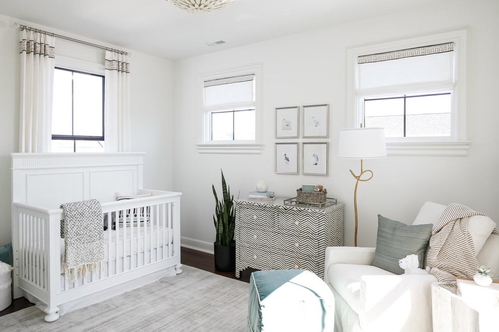 Ejemplo de habitación de bebé neutra clásica renovada con paredes blancas y suelo de madera oscura
