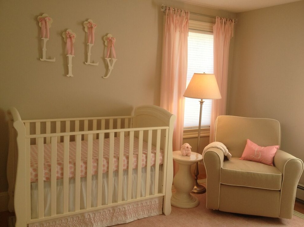 Cette photo montre une petite chambre de bébé fille chic avec un mur beige, parquet foncé et un sol marron.
