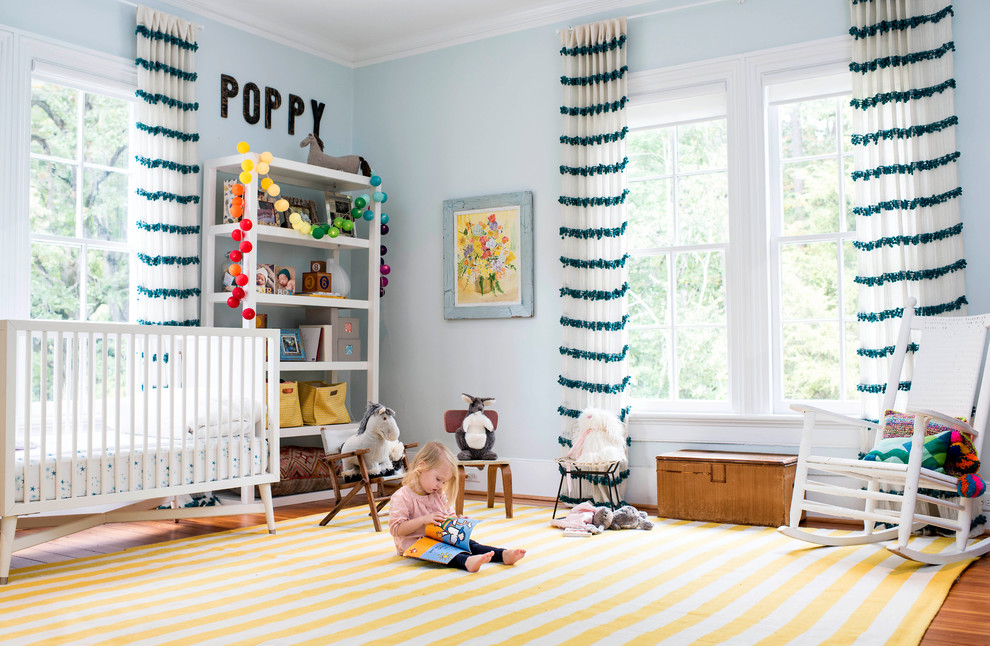 Diseño de habitación de bebé neutra campestre con paredes azules y suelo amarillo