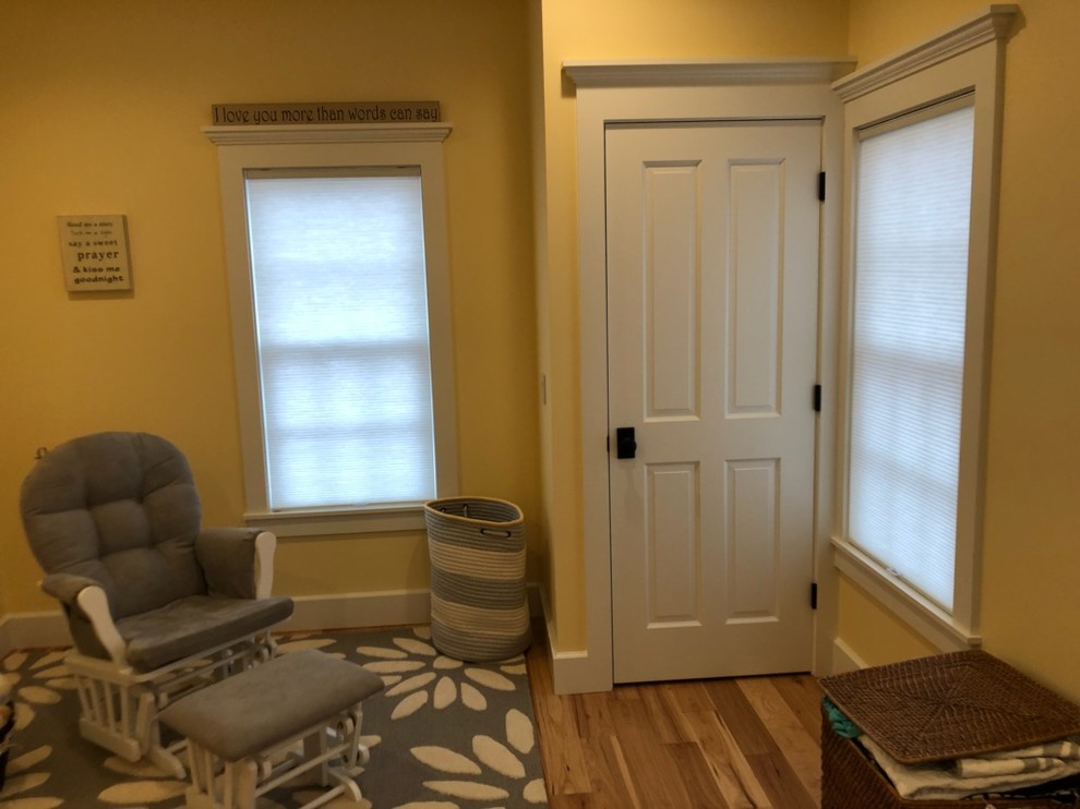 Mittelgroßes Klassisches Babyzimmer mit gelber Wandfarbe, braunem Holzboden und beigem Boden in Burlington