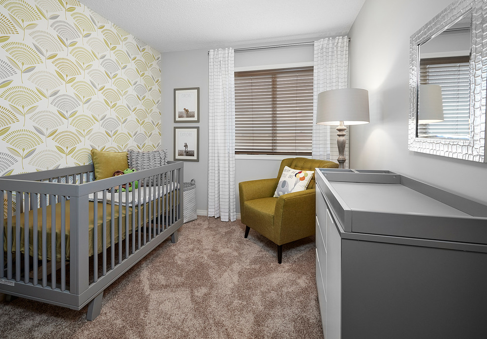 Diseño de habitación de bebé neutra actual de tamaño medio con paredes amarillas y moqueta