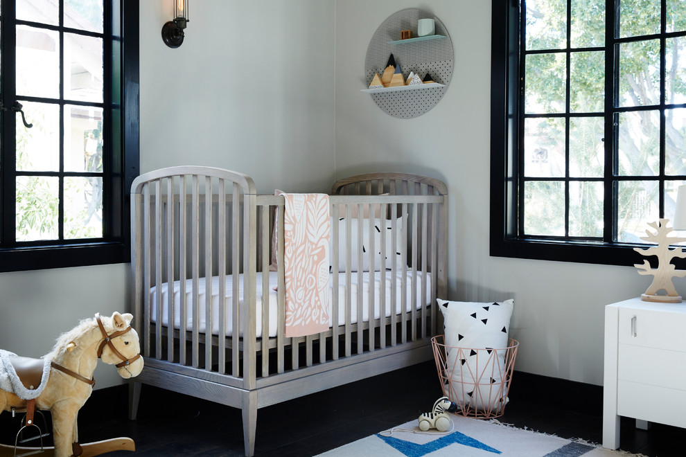 Aménagement d'une chambre de bébé neutre classique avec un mur blanc, parquet foncé et un sol noir.