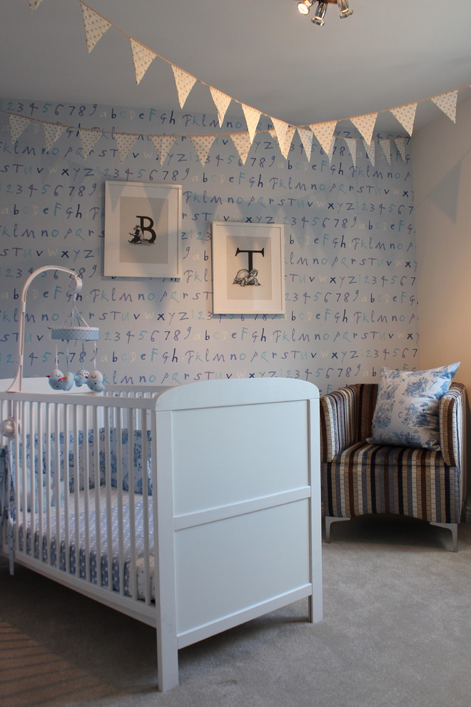Inspiration for a timeless boy carpeted nursery remodel in London with blue walls