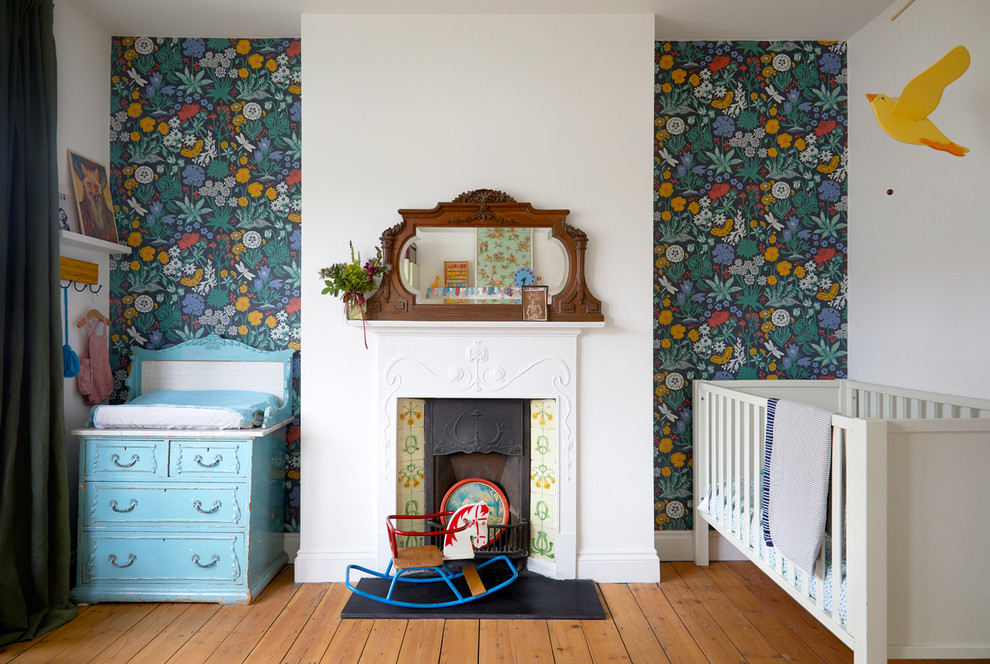 Neutrales Stilmix Babyzimmer mit grüner Wandfarbe, braunem Holzboden und braunem Boden in London