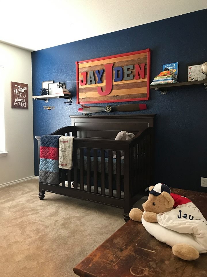 Exemple d'une chambre de bébé garçon chic de taille moyenne avec un mur multicolore, moquette et un sol beige.