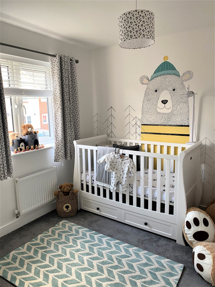 Modelo de habitación de bebé neutra campestre de tamaño medio con paredes blancas, moqueta y suelo gris