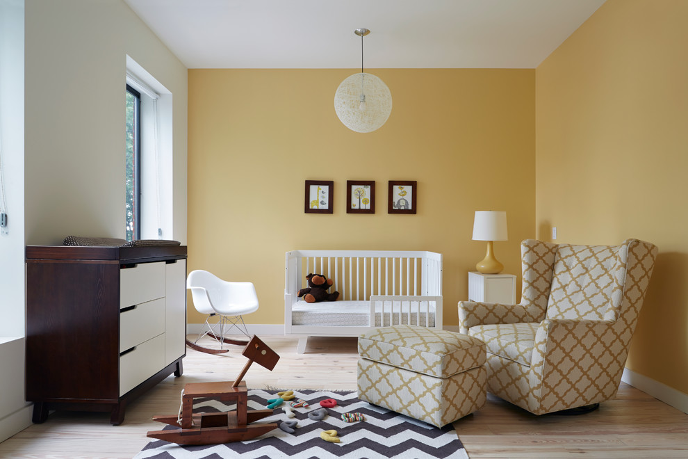 Inspiration för moderna könsneutrala babyrum, med gula väggar, ljust trägolv och beiget golv