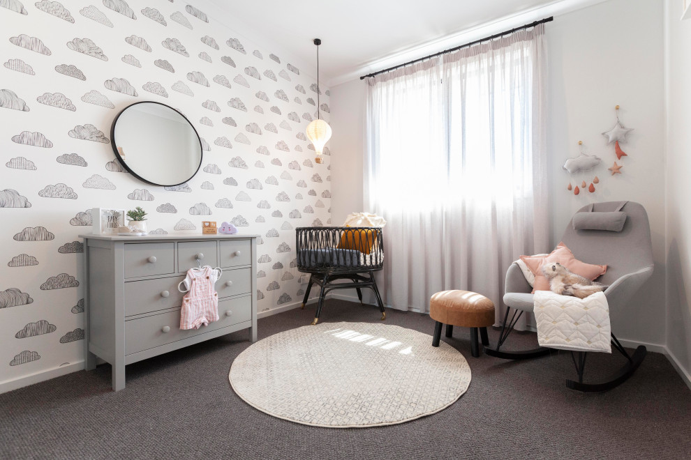 Immagine di una cameretta per neonata contemporanea con pareti bianche, pavimento grigio, carta da parati e moquette