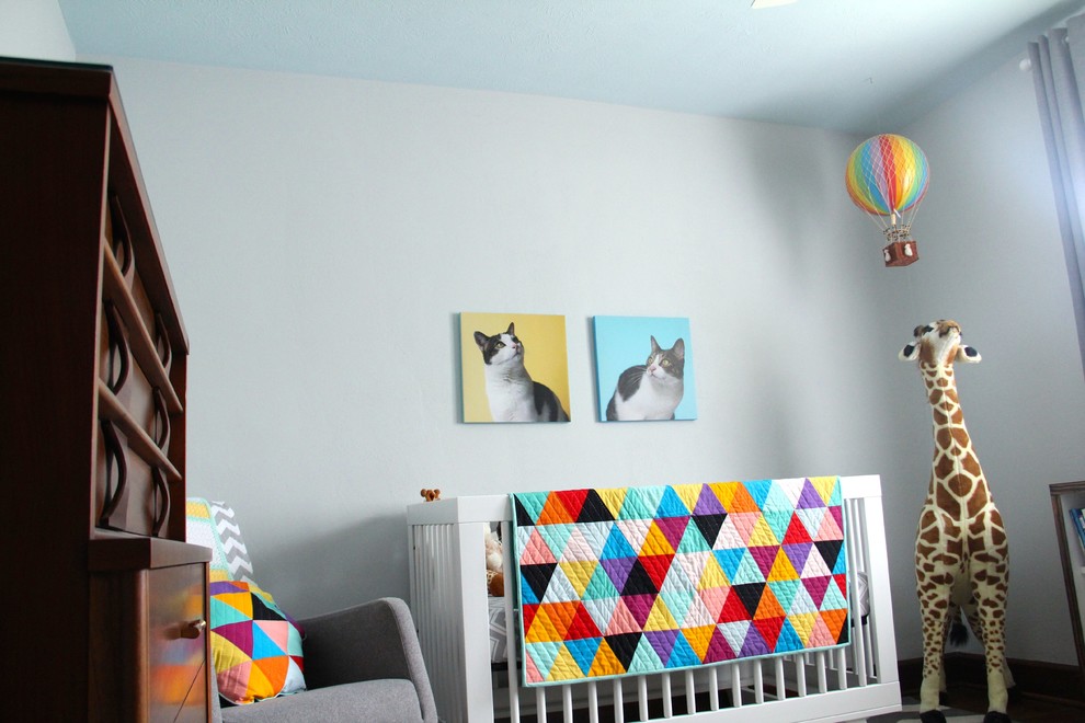 Foto de habitación de bebé neutra tradicional de tamaño medio con paredes grises, suelo de madera oscura y suelo marrón