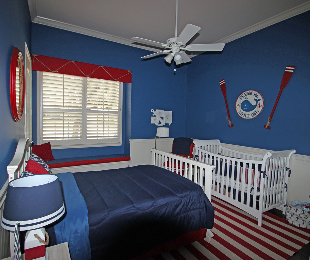 This is an example of a medium sized classic nursery for boys in Dallas with blue walls and medium hardwood flooring.