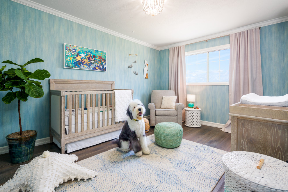 Foto de habitación de bebé neutra costera con paredes azules, suelo de madera oscura, suelo marrón y papel pintado