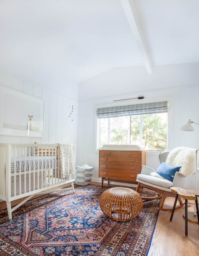 Réalisation d'une chambre de bébé neutre design avec un mur blanc.