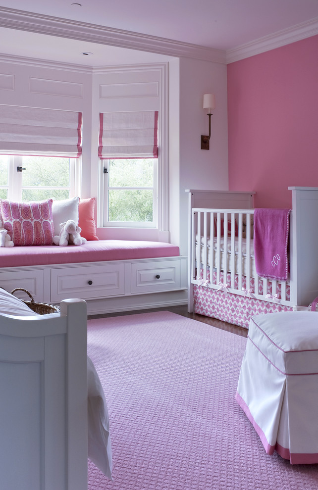 На фото: комната для малыша среднего размера в классическом стиле с розовыми стенами для девочки с