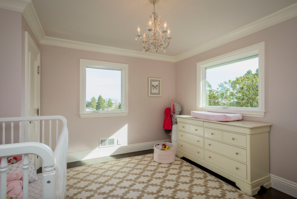 Photo of a medium sized traditional nursery for girls in San Francisco with pink walls and dark hardwood flooring.