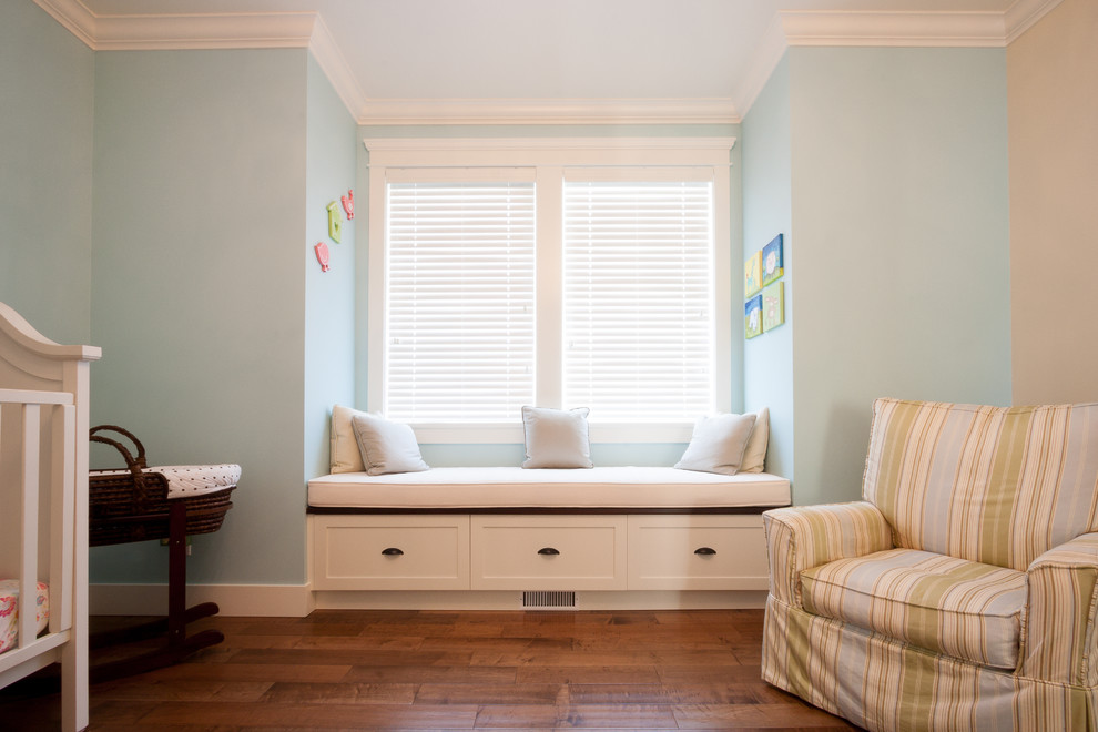Inspiration pour une grande chambre de bébé neutre traditionnelle avec un mur bleu, parquet foncé et un sol marron.
