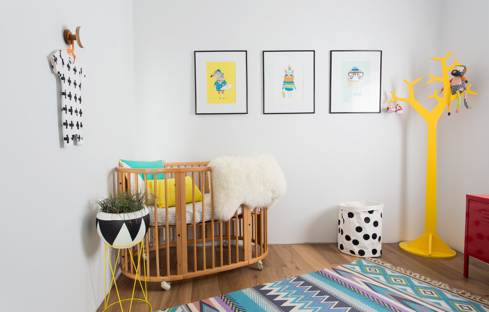 Photo of a medium sized scandi gender neutral nursery in Wollongong with white walls and light hardwood flooring.