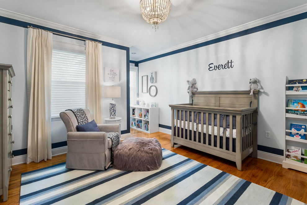 Idee per una cameretta per neonato classica con pareti bianche, pavimento in legno massello medio e pavimento marrone