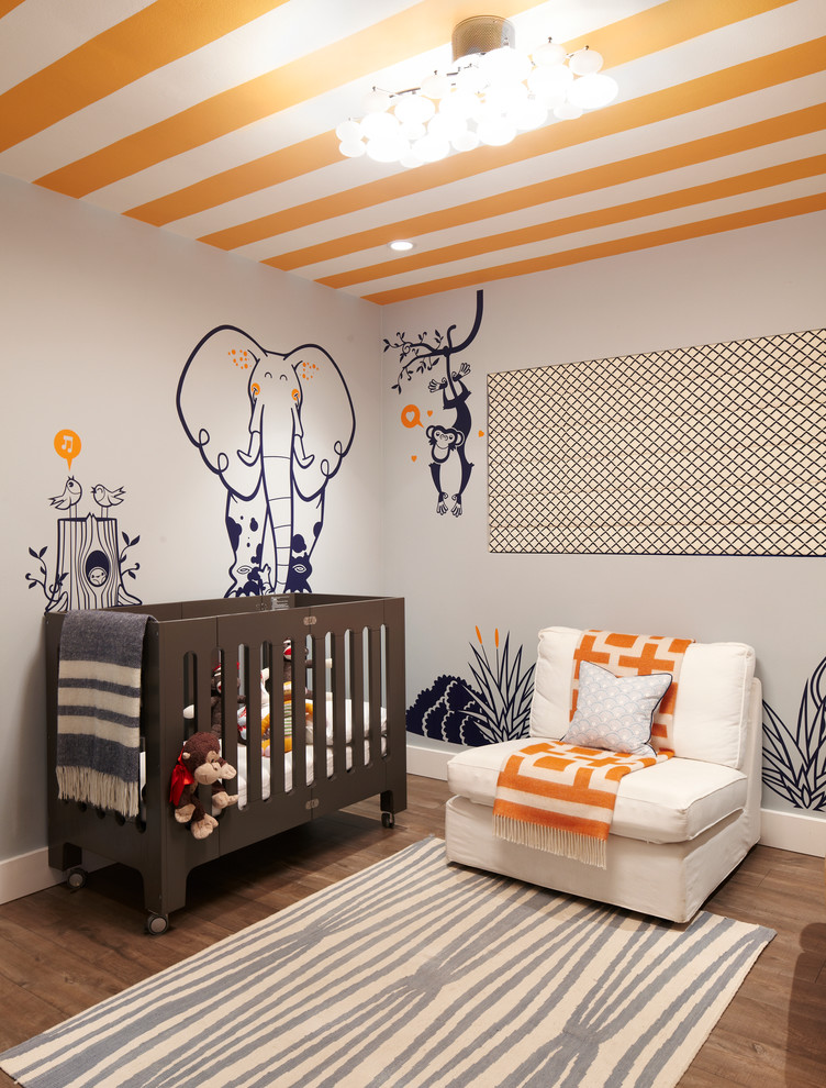 Neutrales Maritimes Babyzimmer mit grauer Wandfarbe, braunem Holzboden und braunem Boden in Los Angeles