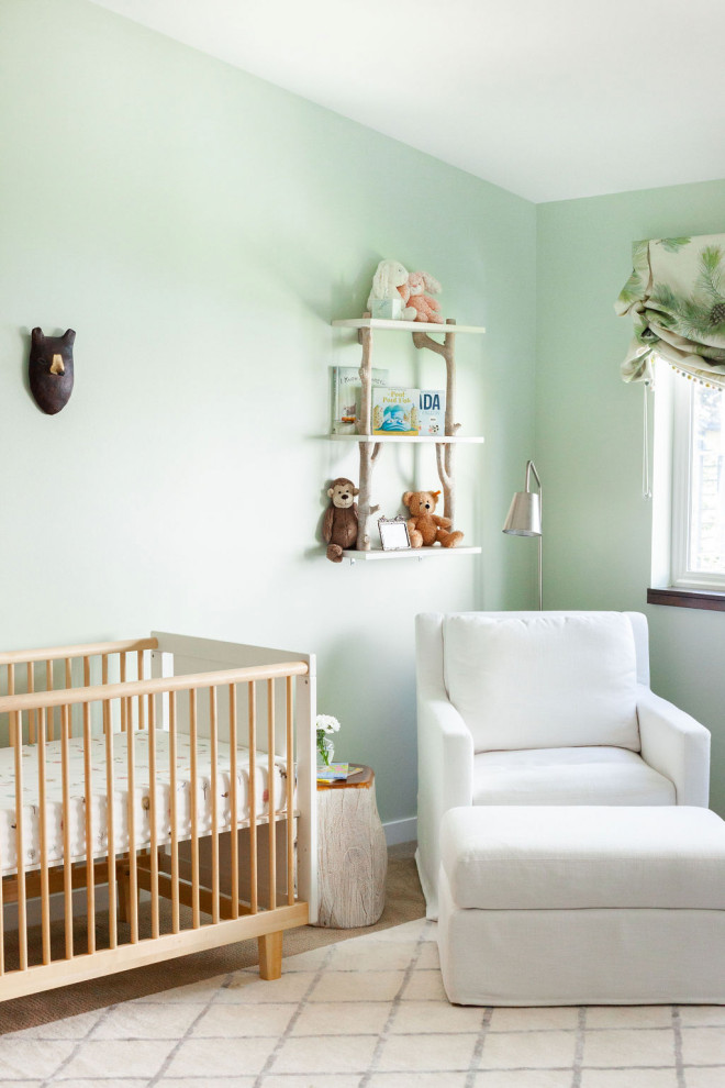 Idée de décoration pour une chambre de bébé neutre design avec un mur vert, un sol en bois brun et un sol marron.
