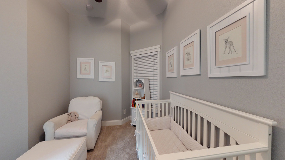 Idée de décoration pour une chambre de bébé fille marine avec un mur gris et moquette.