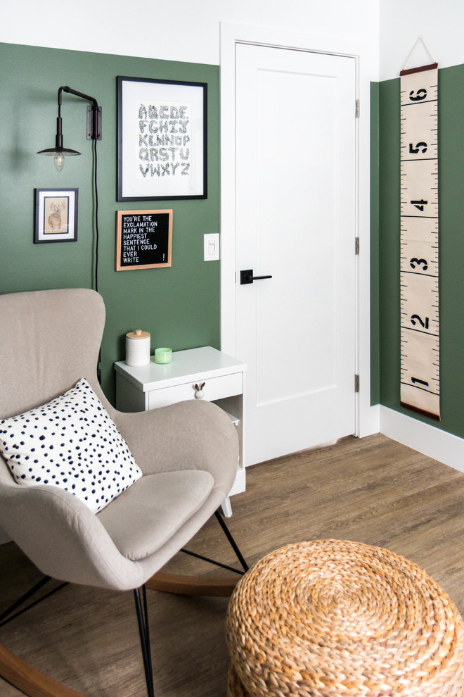 Aménagement d'une petite chambre de bébé neutre moderne avec un mur vert, un sol en vinyl et un sol marron.