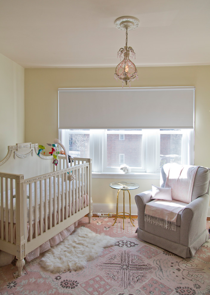 Diseño de habitación de bebé niña clásica renovada de tamaño medio con paredes beige, suelo de madera en tonos medios y suelo marrón