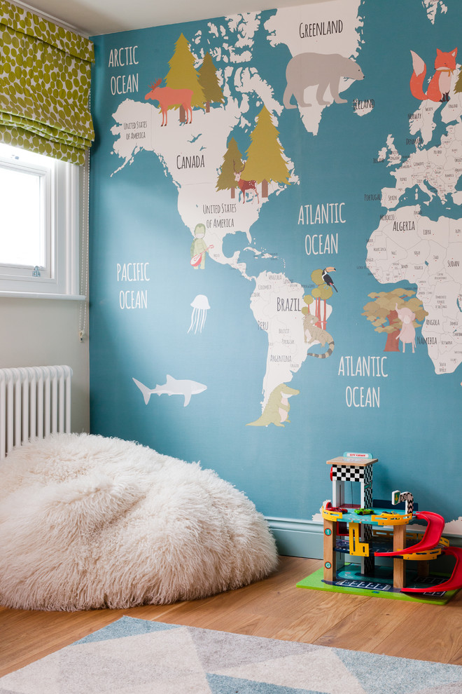 Inspiration for a small contemporary nursery for boys in London with blue walls, light hardwood flooring and brown floors.