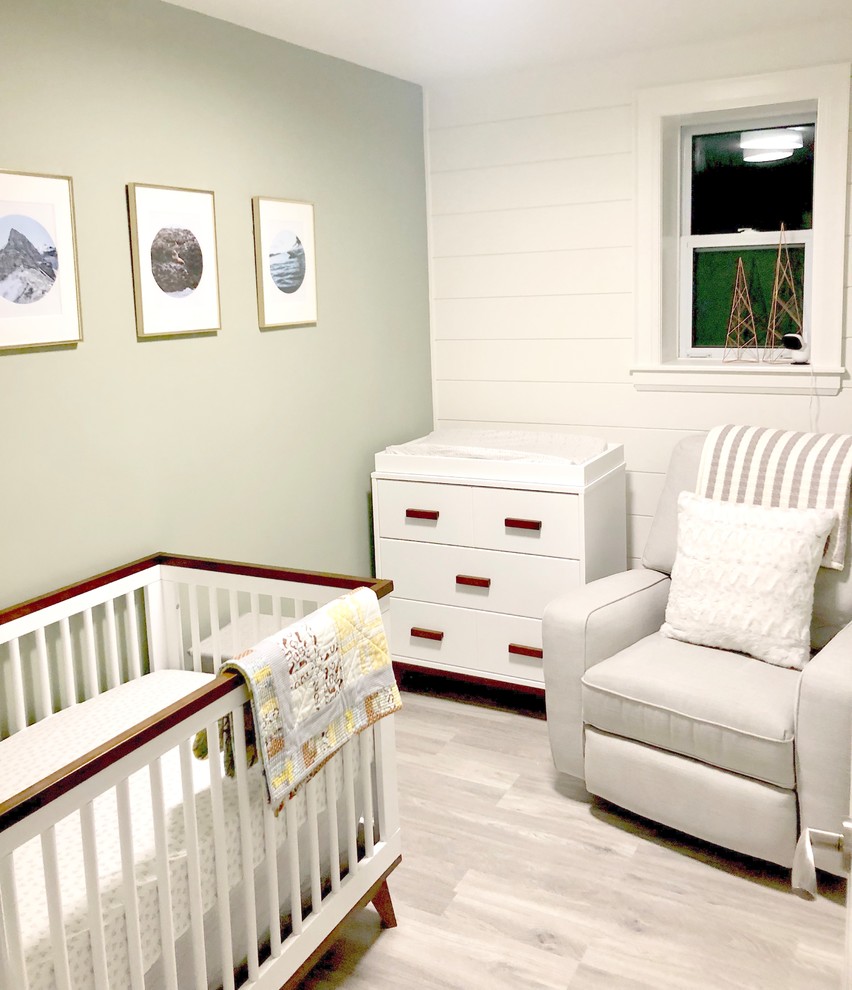 Esempio di una piccola cameretta per neonati neutra minimal con pareti verdi, pavimento in laminato e pavimento grigio