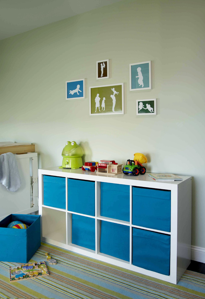 This is an example of a modern nursery for boys in New York with green walls and dark hardwood flooring.
