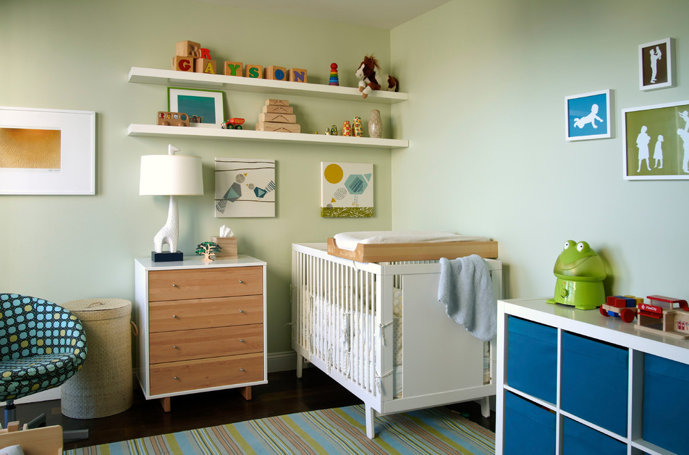 Design ideas for a modern nursery for boys in New York with green walls and dark hardwood flooring.