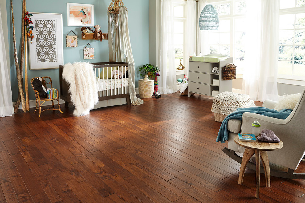 Ejemplo de habitación de bebé romántica con paredes azules, suelo de madera en tonos medios y suelo marrón