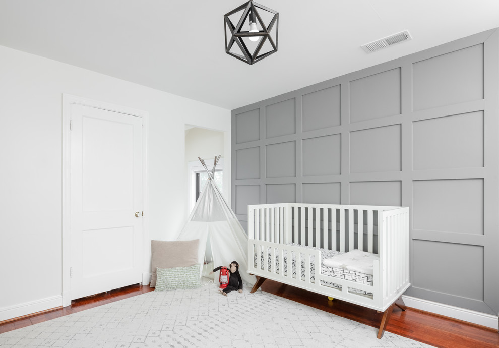 Immagine di una cameretta per neonati neutra chic di medie dimensioni con parquet scuro, pavimento marrone e pareti bianche