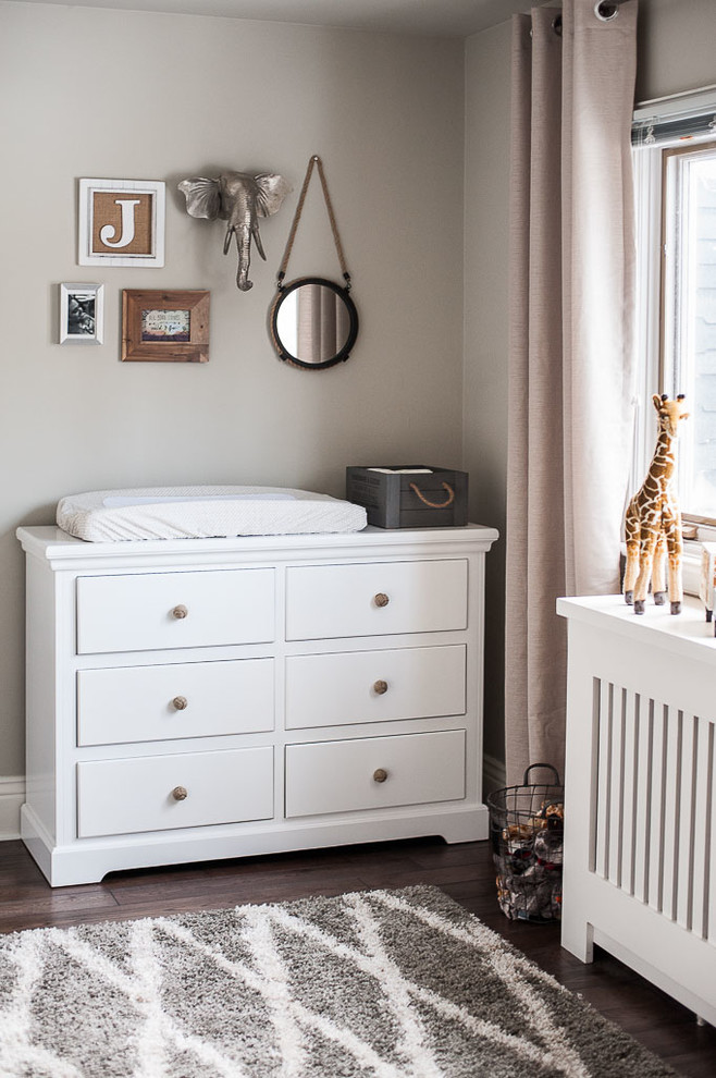 Imagen de habitación de bebé neutra clásica renovada de tamaño medio con paredes grises y suelo de madera oscura