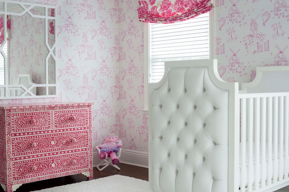 Ejemplo de habitación de bebé niña clásica de tamaño medio con paredes rosas, suelo de madera oscura y suelo marrón